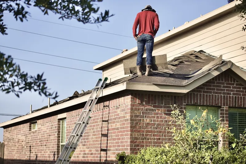 Professional roofer working on a residential roof in Ayres